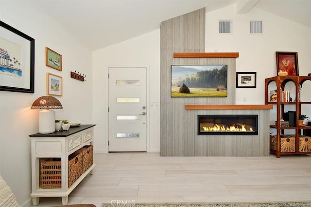 entryway featuring lofted ceiling with beams and light hardwood / wood-style flooring