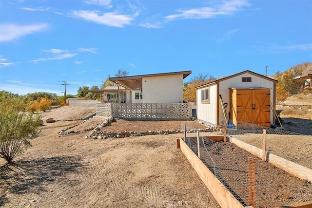 back of property featuring a storage shed