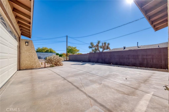 view of patio with a garage and fence