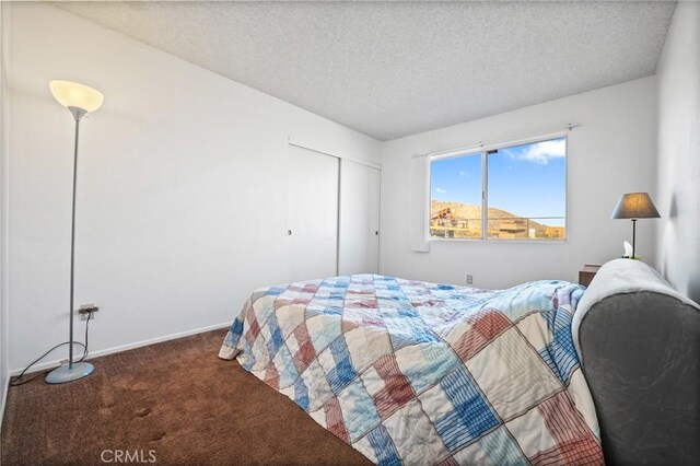 carpeted bedroom with a closet and a textured ceiling