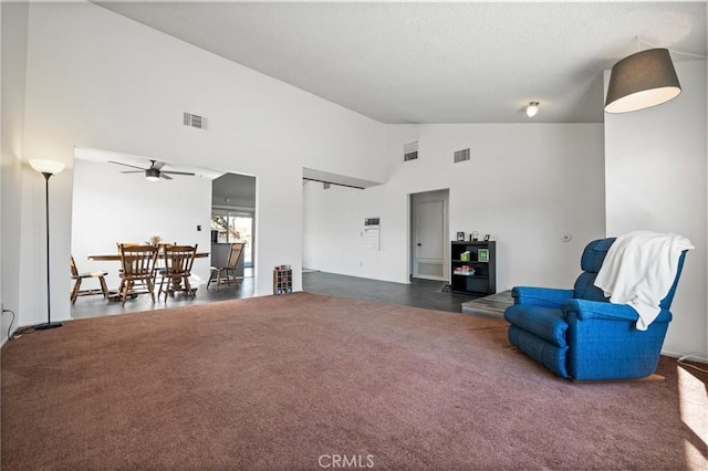 sitting room featuring high vaulted ceiling, ceiling fan, visible vents, and dark carpet