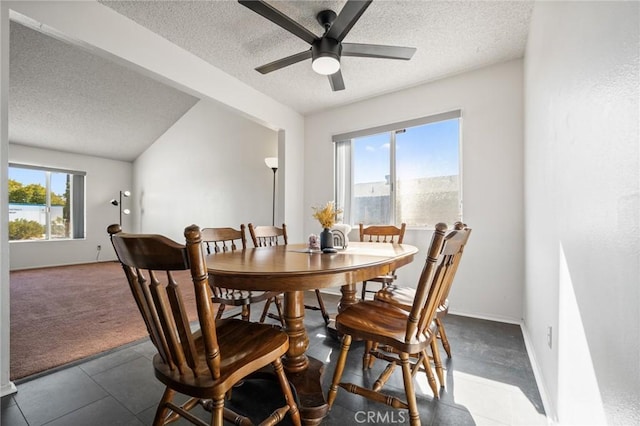 carpeted dining room with ceiling fan and a textured ceiling