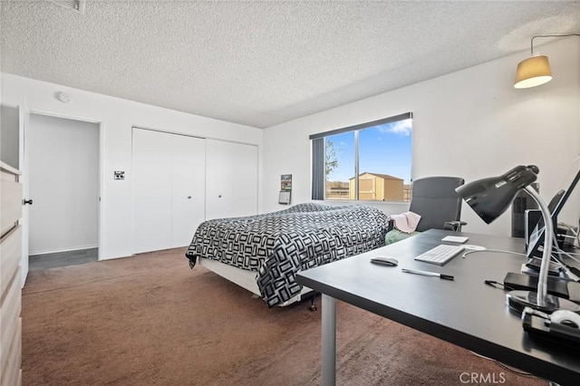 bedroom with a closet, dark carpet, and a textured ceiling