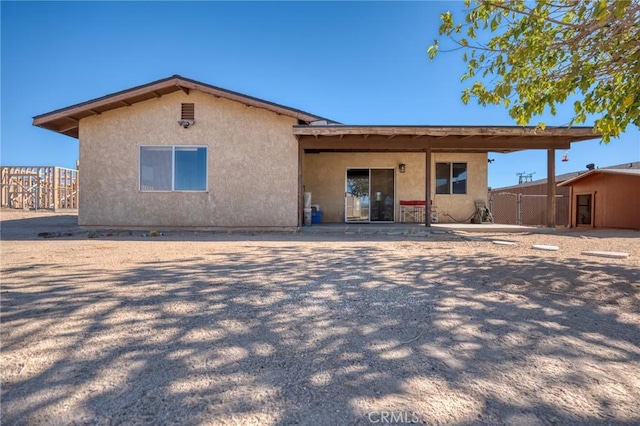 rear view of house with stucco siding