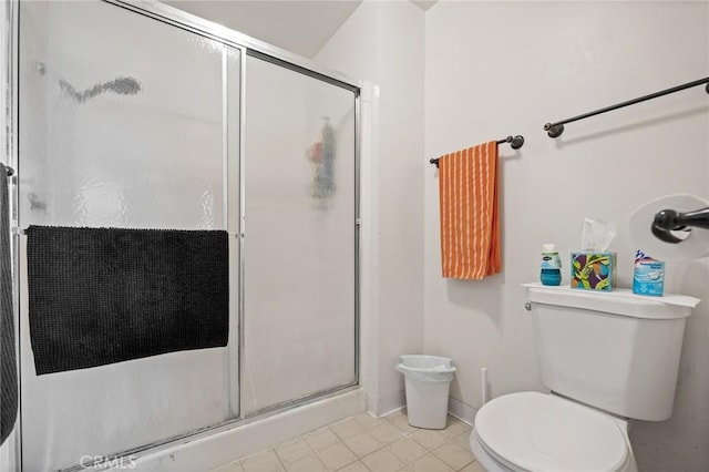 full bath featuring a stall shower, toilet, and baseboards