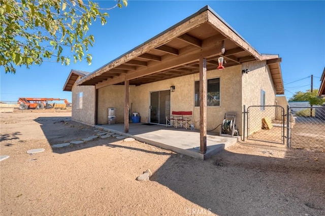 back of property featuring a patio, fence, and stucco siding