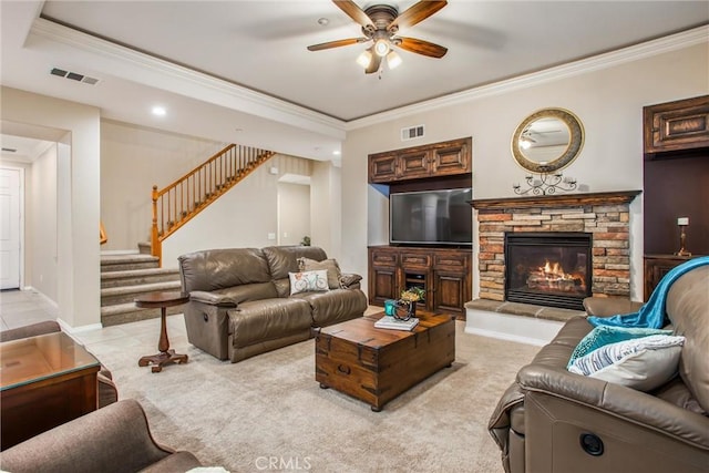 carpeted living room featuring a fireplace, ceiling fan, and crown molding