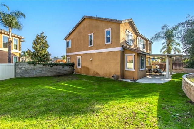 rear view of property with a patio and a lawn