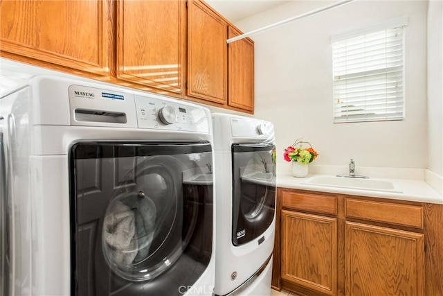 laundry area with separate washer and dryer, sink, and cabinets