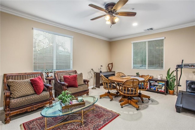 carpeted living room with crown molding and ceiling fan