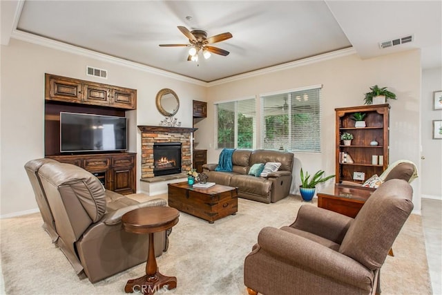 living room featuring a stone fireplace, ceiling fan, and crown molding