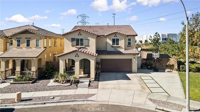 mediterranean / spanish-style home featuring covered porch and a garage