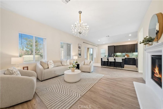 living room featuring a notable chandelier and light wood-type flooring