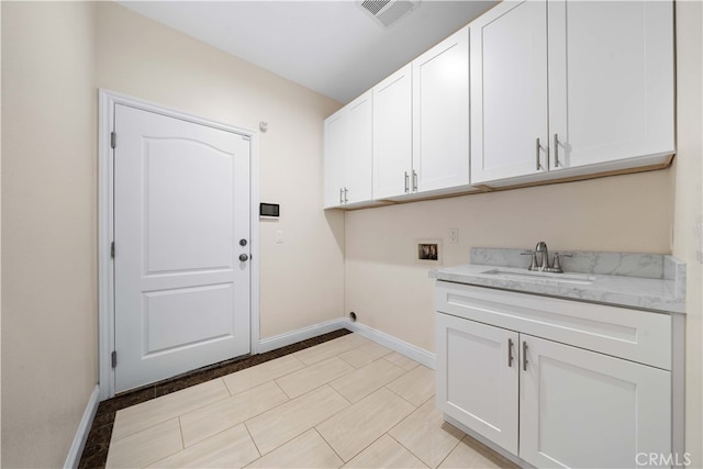 clothes washing area with cabinets, sink, and washer hookup