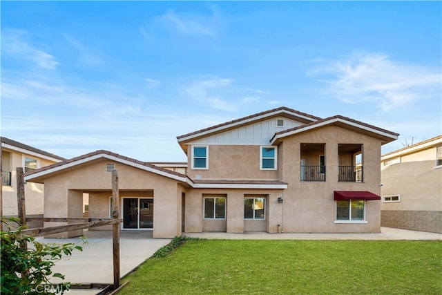 back of house with a balcony, a yard, and a patio