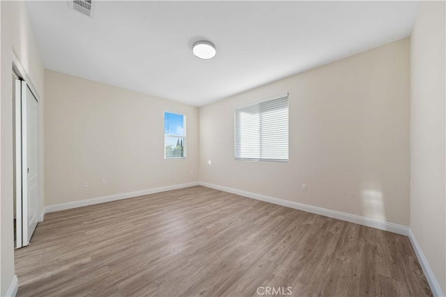 unfurnished bedroom featuring a closet and light wood-type flooring