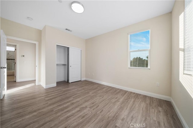 unfurnished bedroom featuring hardwood / wood-style flooring and a closet