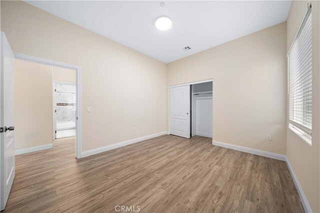 unfurnished bedroom featuring a closet and light hardwood / wood-style floors