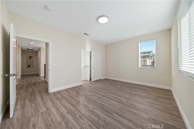 unfurnished bedroom featuring light hardwood / wood-style floors and a closet