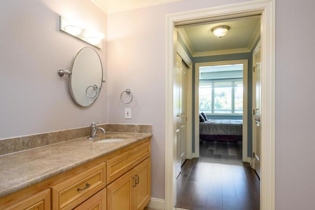 bathroom featuring crown molding, hardwood / wood-style floors, and vanity