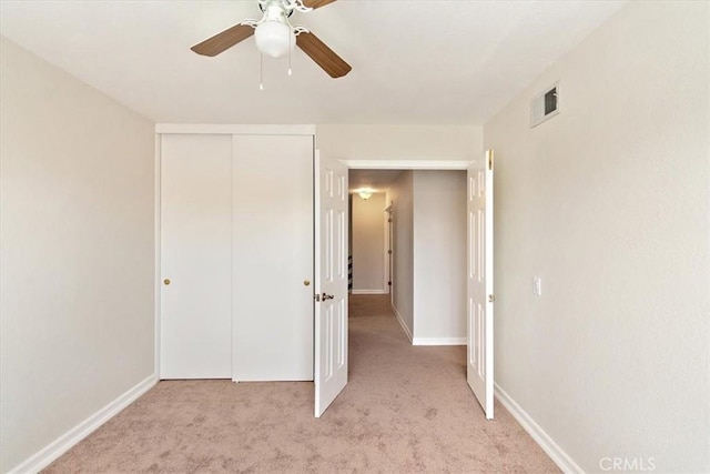 unfurnished bedroom with a closet, ceiling fan, and light colored carpet