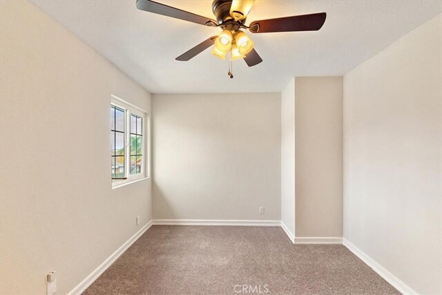 carpeted spare room featuring ceiling fan