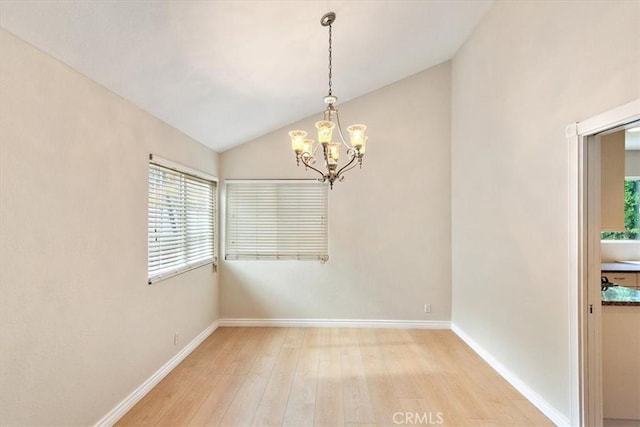 spare room with light hardwood / wood-style floors, lofted ceiling, and a chandelier