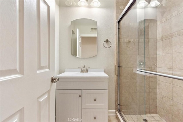 bathroom with vanity and a shower with door