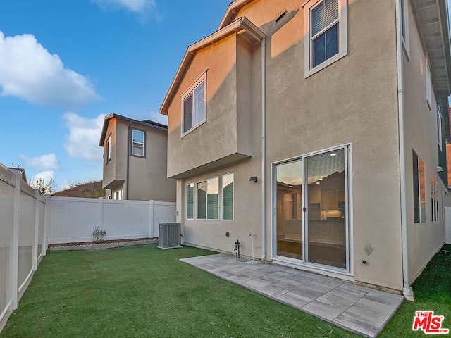 back of house featuring a yard, a patio, and central air condition unit