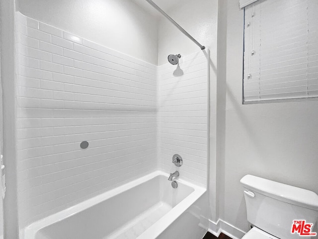 bathroom featuring toilet and tiled shower / bath