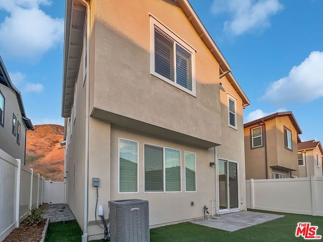 back of house with a patio and central AC