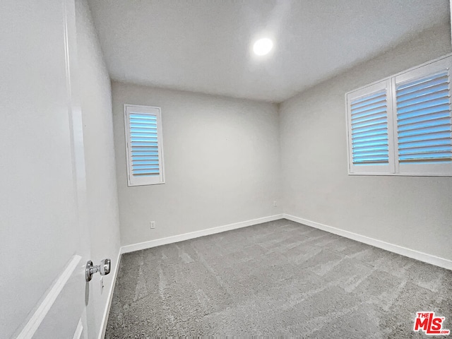 carpeted spare room with a textured ceiling and a wealth of natural light