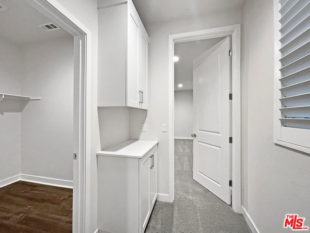 hallway featuring dark colored carpet