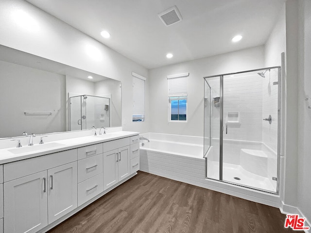 bathroom with hardwood / wood-style floors, vanity, and shower with separate bathtub