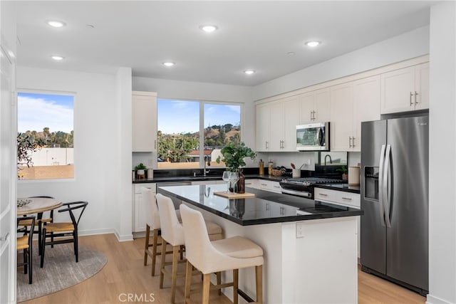 kitchen with a center island, stainless steel appliances, and white cabinetry