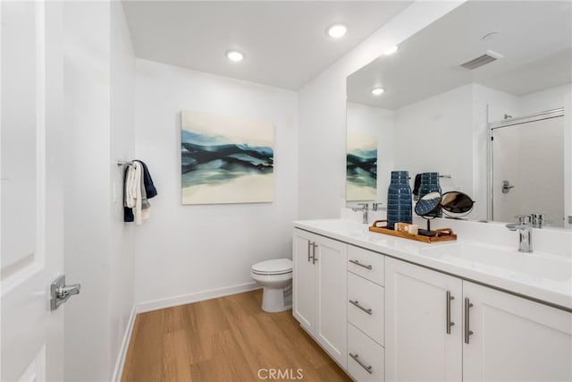 bathroom featuring hardwood / wood-style floors, vanity, an enclosed shower, and toilet