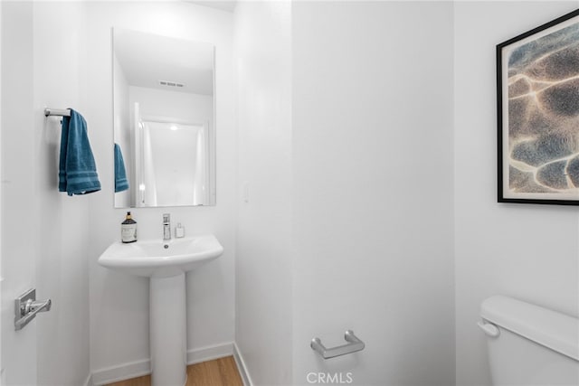 bathroom with hardwood / wood-style floors, toilet, and sink