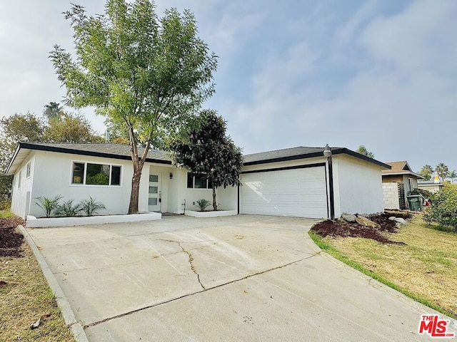 ranch-style home with a garage and a front lawn