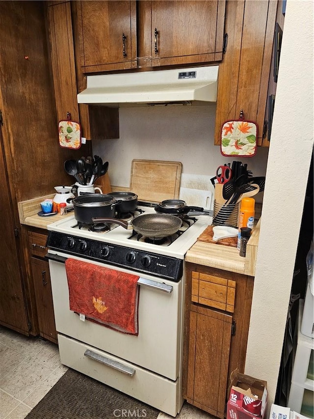 kitchen with light tile patterned flooring and white range with gas stovetop