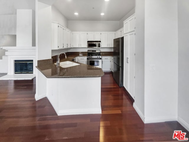 kitchen featuring sink, kitchen peninsula, stainless steel appliances, and dark wood-type flooring