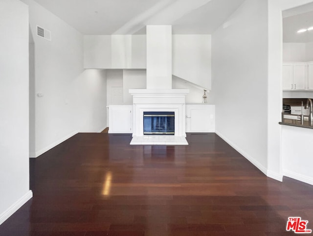 unfurnished living room with dark wood-type flooring and sink