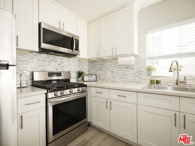 kitchen featuring white cabinets, stainless steel appliances, and sink