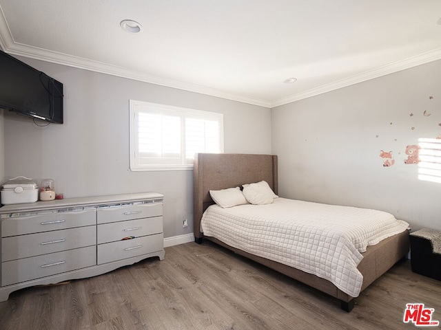 bedroom with crown molding and light hardwood / wood-style flooring