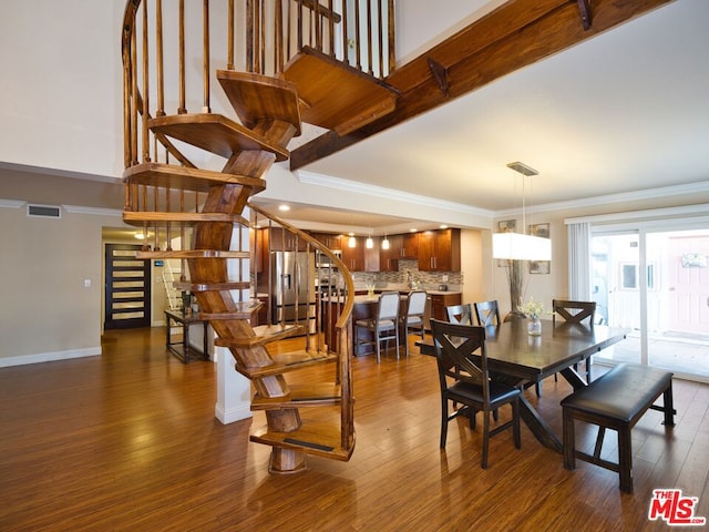 dining area featuring dark wood-type flooring and ornamental molding