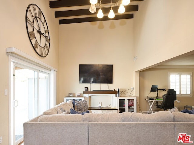 living room with a towering ceiling and beamed ceiling