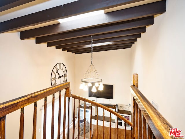 staircase featuring beamed ceiling