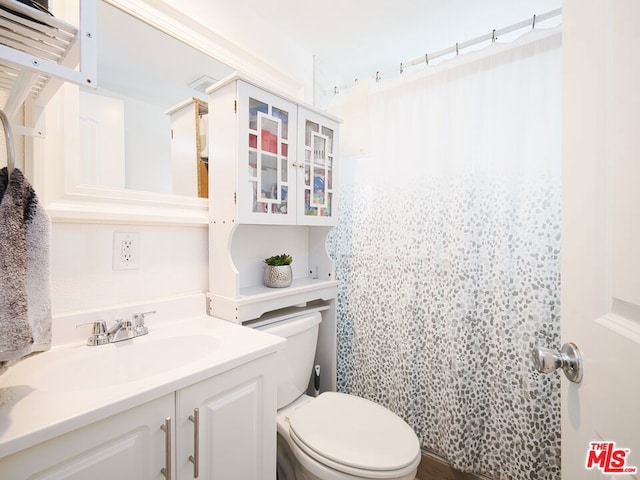 bathroom featuring vanity, curtained shower, and toilet