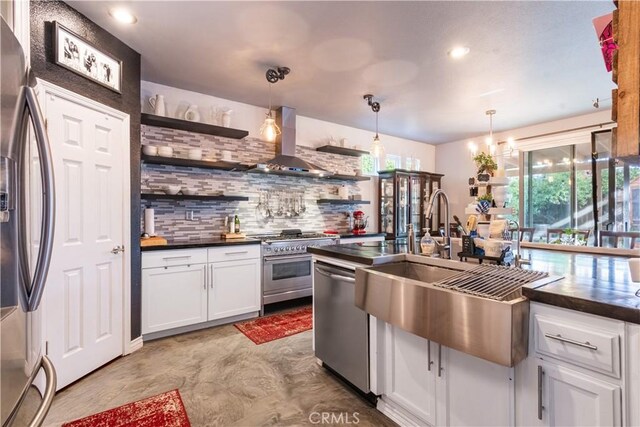 kitchen with tasteful backsplash, pendant lighting, white cabinetry, appliances with stainless steel finishes, and wall chimney exhaust hood