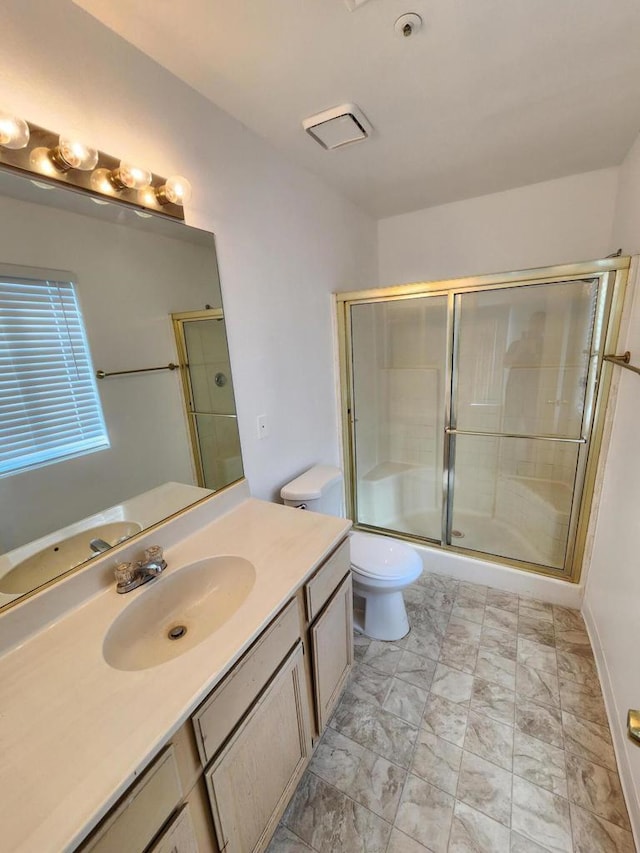 bathroom featuring vanity, toilet, and an enclosed shower