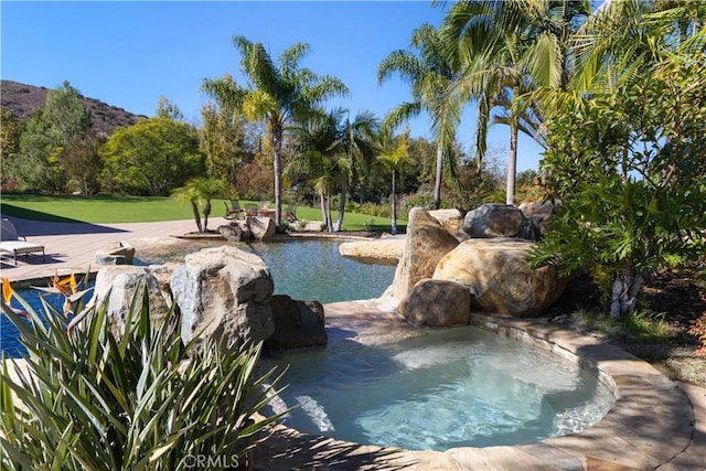 view of swimming pool with a mountain view and a yard